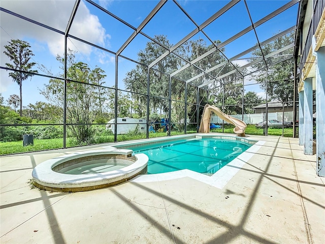 view of pool featuring a lanai, a patio, a water slide, and an in ground hot tub