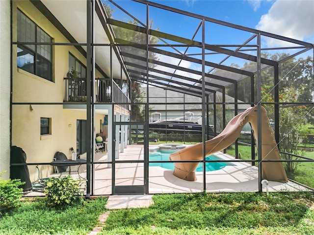 view of pool featuring an in ground hot tub, a patio, glass enclosure, and a water slide