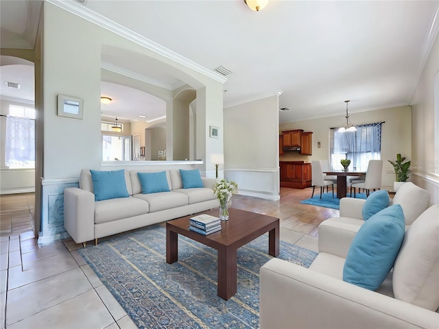 tiled living room featuring ornamental molding and plenty of natural light