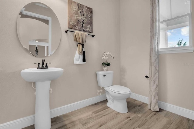 bathroom with toilet and hardwood / wood-style flooring