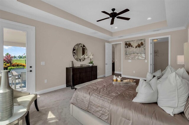 bedroom featuring access to exterior, a raised ceiling, light colored carpet, and baseboards