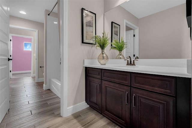 full bath with recessed lighting, baseboards, wood finished floors, and vanity