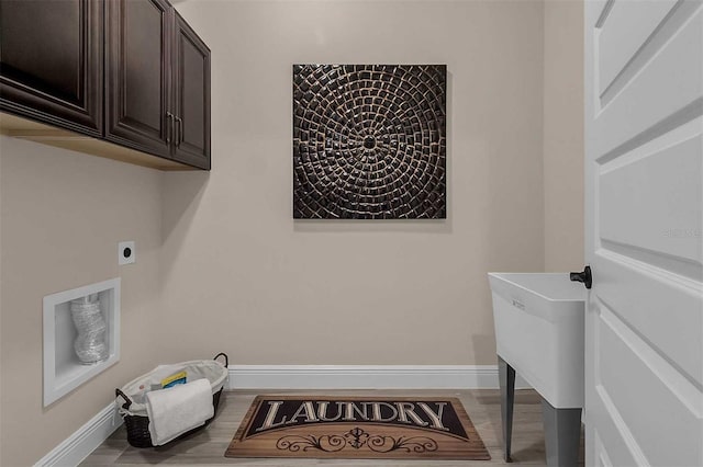 clothes washing area featuring electric dryer hookup, baseboards, and wood finished floors