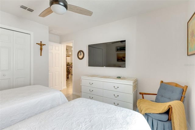 bedroom with ceiling fan, light tile patterned flooring, and a closet