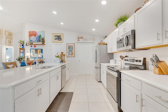 kitchen featuring white cabinetry, sink, stainless steel appliances, vaulted ceiling, and light tile patterned floors