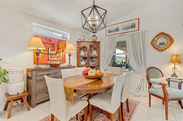 tiled dining room with a chandelier, a healthy amount of sunlight, and lofted ceiling