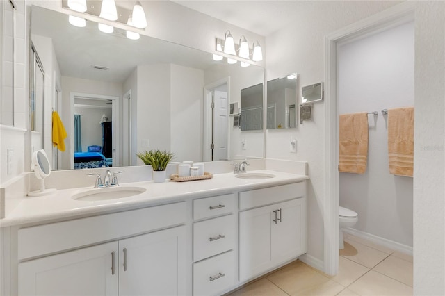 bathroom with tile patterned flooring, vanity, and toilet