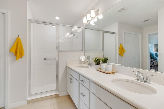 bathroom featuring tile patterned floors, a shower with door, and vanity