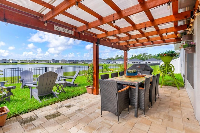 view of patio with a grill, a water view, and a pergola