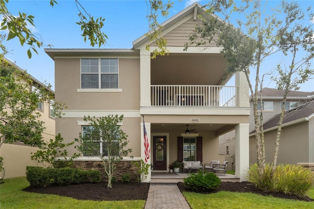 view of front of house featuring a patio area, a balcony, ceiling fan, and an outdoor hangout area