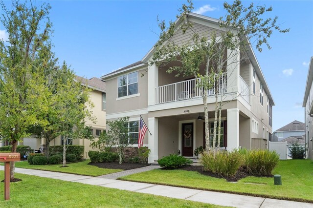 view of front of house with a balcony and a front lawn