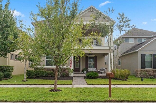 view of front of home featuring a balcony, a front lawn, and covered porch