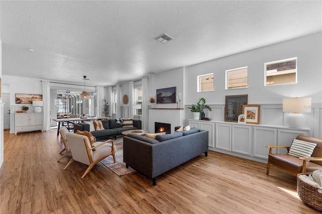 living room with light wood-type flooring and a textured ceiling