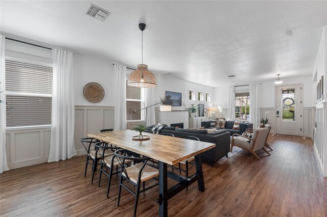 dining space featuring a textured ceiling and dark hardwood / wood-style floors