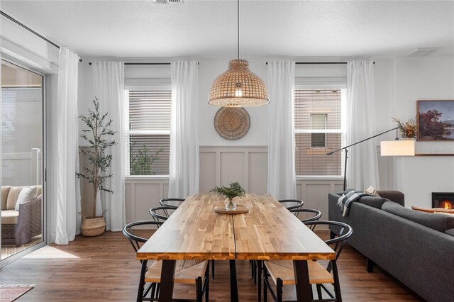 dining room with a textured ceiling, hardwood / wood-style floors, and a wealth of natural light