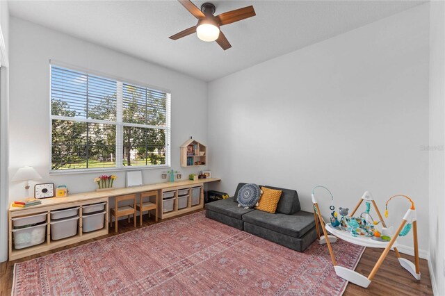 living area with ceiling fan and hardwood / wood-style flooring