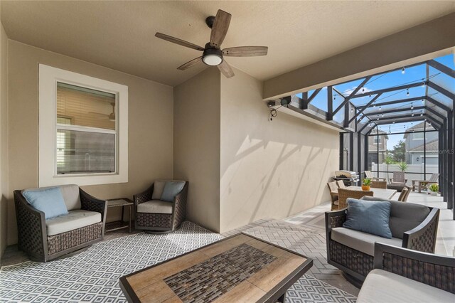 view of patio with ceiling fan, outdoor lounge area, and glass enclosure