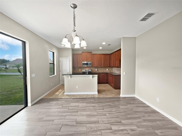 kitchen with pendant lighting, an inviting chandelier, light hardwood / wood-style flooring, and backsplash