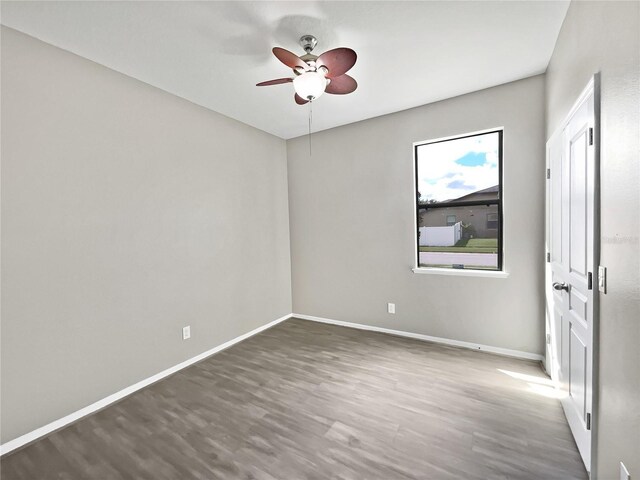 spare room featuring dark wood-type flooring and ceiling fan