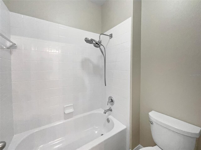 bathroom featuring toilet and tiled shower / bath