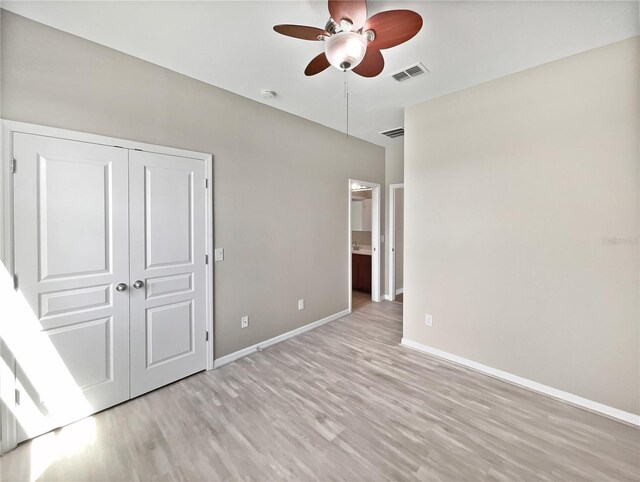 unfurnished bedroom with light wood-type flooring, a closet, and ceiling fan