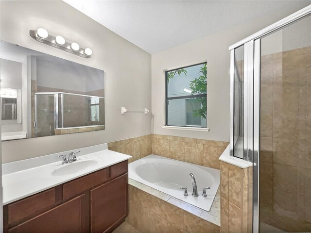 bathroom with vanity and independent shower and bath