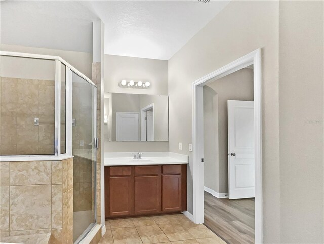 bathroom featuring vanity, wood-type flooring, and a shower with shower door