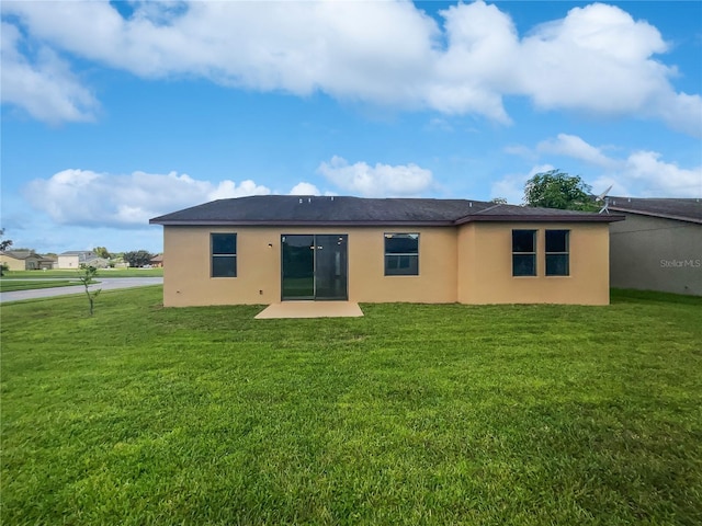 rear view of house featuring a yard and a patio