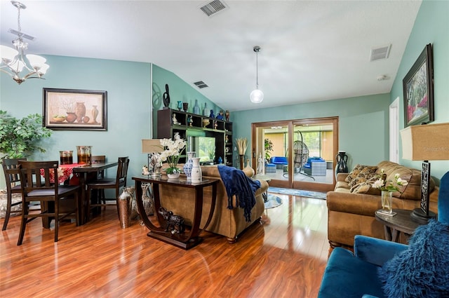 living room featuring lofted ceiling, hardwood / wood-style floors, and a chandelier