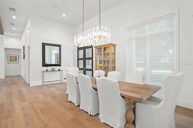 dining area featuring light wood-type flooring and a notable chandelier