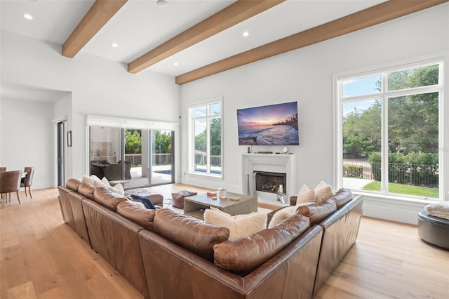 living room with light hardwood / wood-style floors, beamed ceiling, and french doors