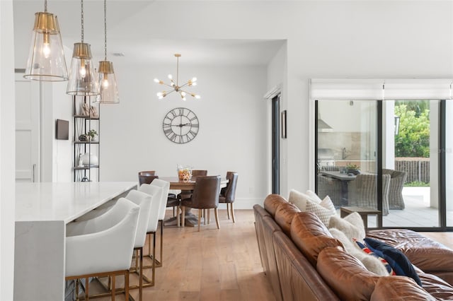 living room with light wood-type flooring and an inviting chandelier