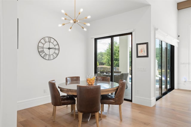 dining area featuring light wood-type flooring and a chandelier