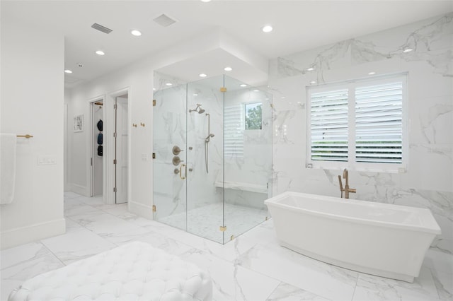 bathroom with tile walls and independent shower and bath