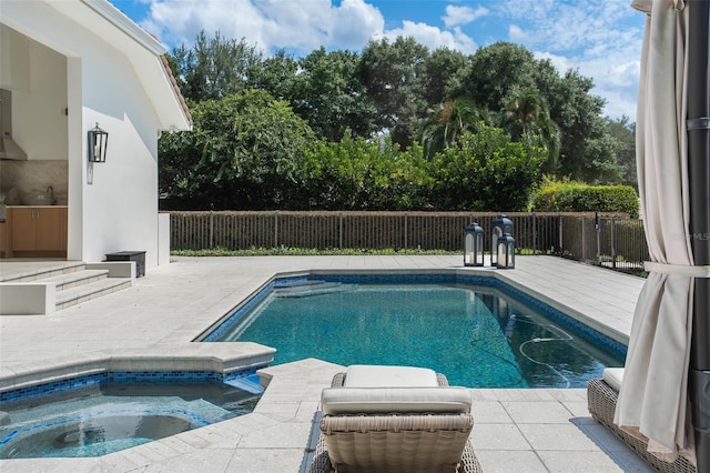 view of swimming pool with an in ground hot tub, sink, and a patio