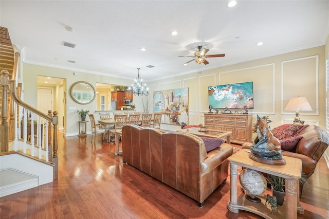 living room with hardwood / wood-style flooring, ceiling fan with notable chandelier, and ornamental molding