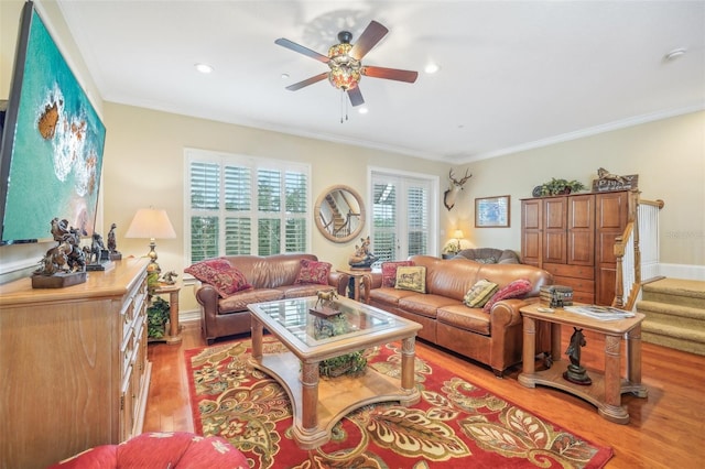 living room with light hardwood / wood-style floors, ceiling fan, and crown molding