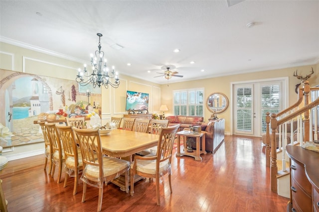 dining area featuring ceiling fan with notable chandelier, ornamental molding, and hardwood / wood-style floors