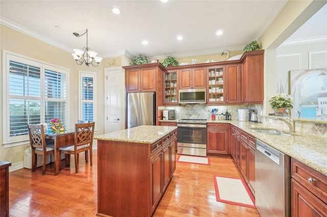 kitchen featuring pendant lighting, a chandelier, appliances with stainless steel finishes, and light hardwood / wood-style flooring