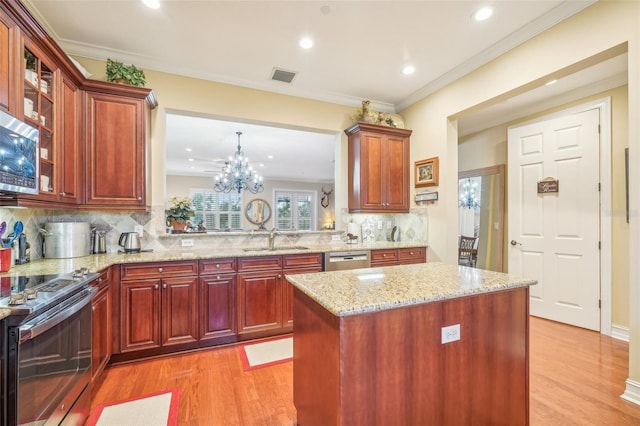 kitchen featuring sink, backsplash, stainless steel appliances, a notable chandelier, and light hardwood / wood-style floors