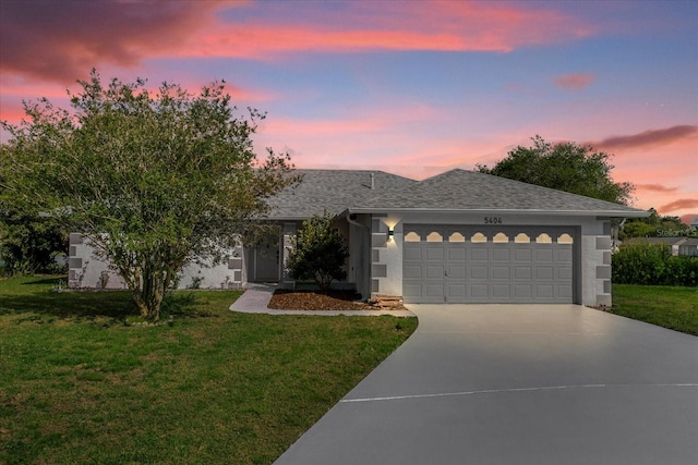 view of front of property with a garage and a yard