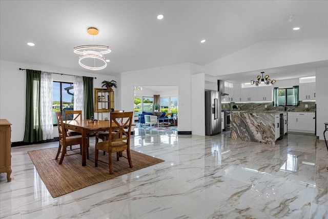 dining space with a notable chandelier and vaulted ceiling