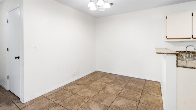 unfurnished dining area with sink and light tile patterned flooring