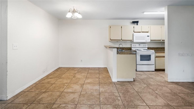 kitchen featuring white appliances, sink, cream cabinetry, a chandelier, and light tile patterned flooring