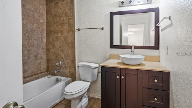 full bathroom with tile patterned flooring, toilet, tiled shower / bath combo, and vanity