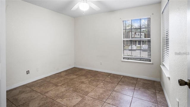 spare room with ceiling fan and tile patterned floors