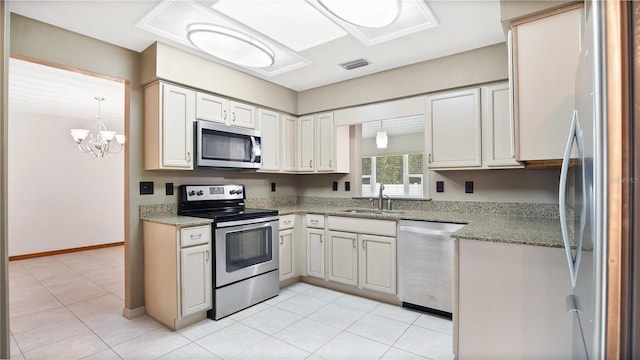 kitchen with sink, appliances with stainless steel finishes, a chandelier, and light tile patterned floors