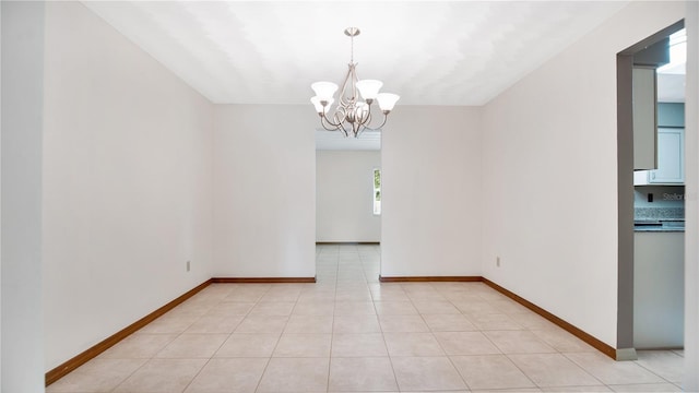 unfurnished dining area featuring light tile patterned flooring and a chandelier