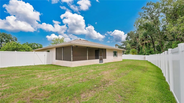 back of house featuring a yard and a sunroom