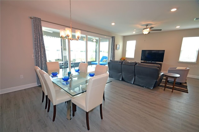 dining room featuring ceiling fan with notable chandelier and dark wood-type flooring